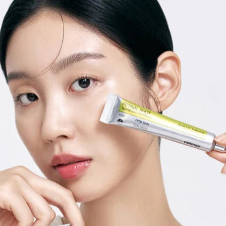 Woman applying eye cream to her face with a white background